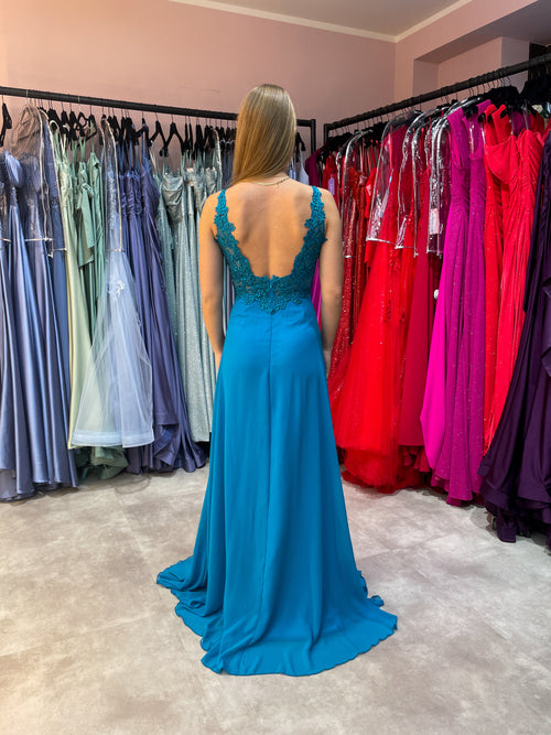 Model trägt luftiges Abendkleid in A-Linie mit Beinschlitz und verziertem Oberteil in einem leuchtenen Türkis