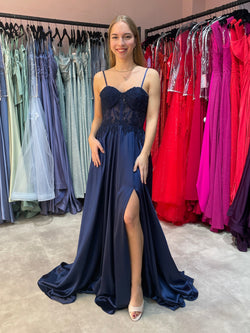 Dunkelblaues Abiballkleid aus fließendem Satinstoff mit Spitzen verziertem Corsagenoberteil und hohem Beinschlitz.