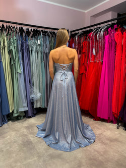 Glitzerndes Abiballkleid in zartem Hellblau mit trägerlosem Bustieroberteil und Rock in A-Linie. Das Kleid hat eine Rückenschnürung und einen hohen Beinschlitz sowie seitliche Einschubtaschen.