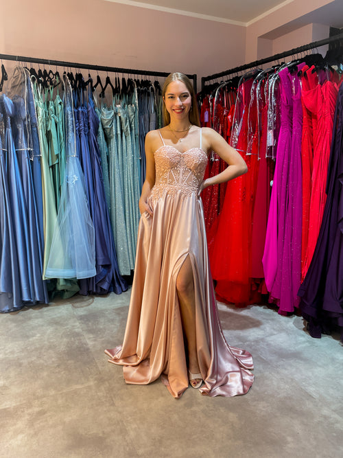 Rosefarbenes Abiballkleid aus fließendem Satinstoff mit Spitzen verziertem Corsagenoberteil und hohem Beinschlitz.