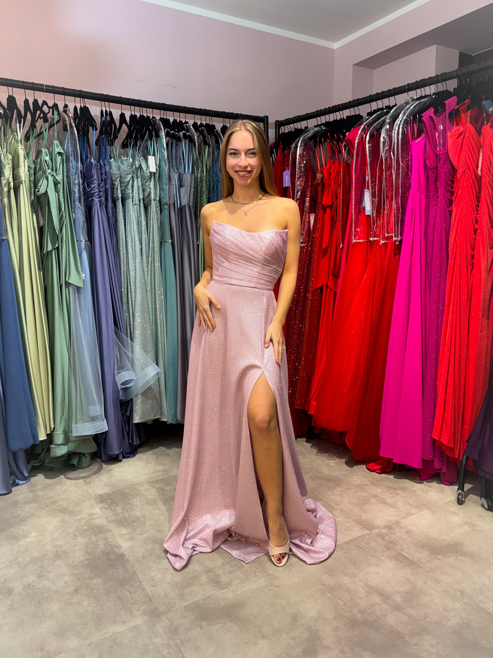 Model trägt ein trägesloses Bustierkleid aus glitzerndem Stoff in Rosa für den Abiball