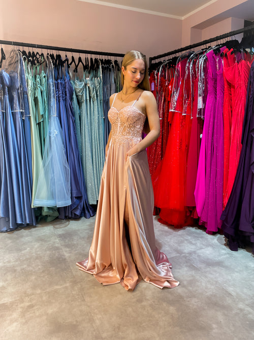 Rosefarbenes Abiballkleid aus fließendem Satinstoff mit Spitzen verziertem Corsagenoberteil und hohem Beinschlitz.